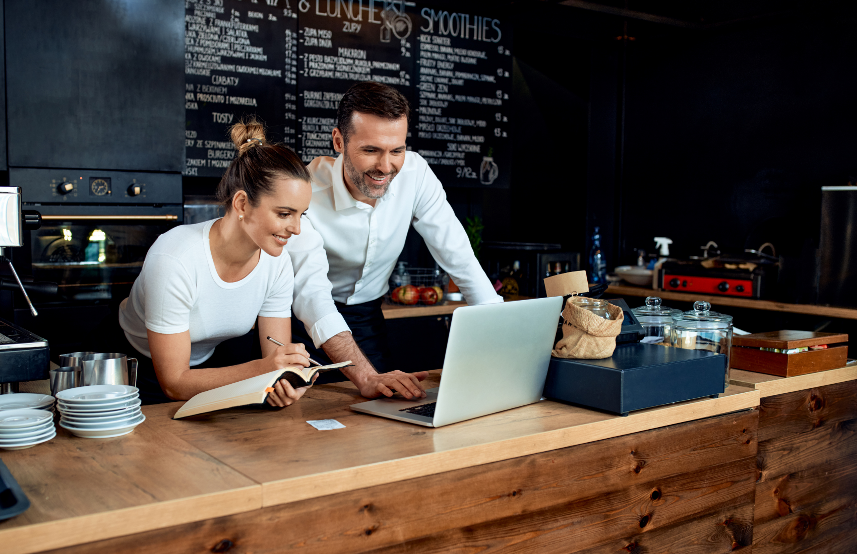 Two people reviewing business data on a laptop